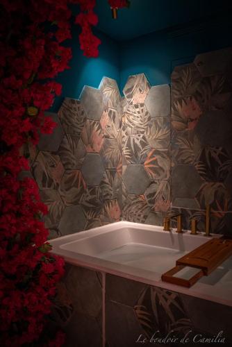 a bath tub in a bathroom with a stone wall at Le Boudoir in Vallauris