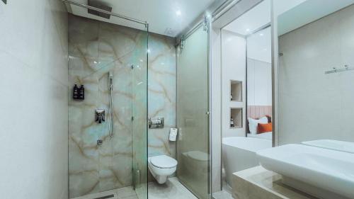 a bathroom with a shower and a toilet and a sink at TheMirell Hôtel Dakhla in Dakhla