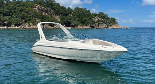 un barco blanco sentado en el agua en el océano en Flamboyant Boat, en Ubatuba