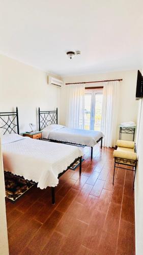 a bedroom with two beds and a chair at Residencial A Cista in Vila da Ponte