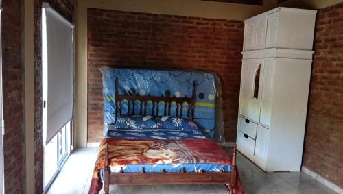 une chambre avec un lit et un mur de briques dans l'établissement El gringo, à Victoria