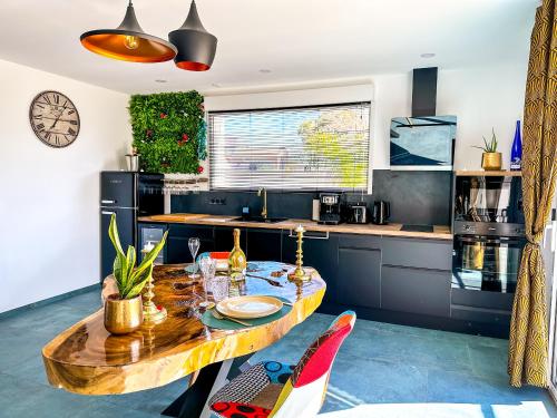 une cuisine avec une table en bois dans une pièce dans l'établissement love room Villa Des Charmes-34450 vias, à Vias