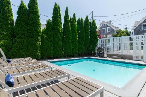 a swimming pool with chaise lounges at Condo with Wading Pool Dog Welcome in Provincetown
