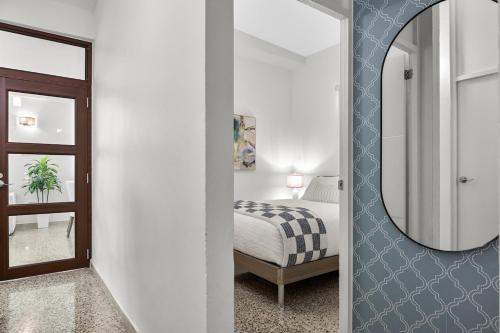 圣胡安Porta Linda Modern House Near The Airport的一间带镜子的卧室和一张位于客房内的床