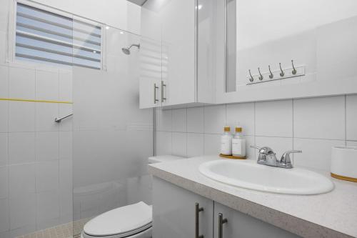 圣胡安Porta Linda Modern House Near The Airport的带水槽和马桶的白色浴室