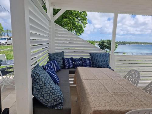 a pergola with a table and pillows on a patio at Maison confortable à Saint Louis, 120 m², vue mer in Îlet à Christophe