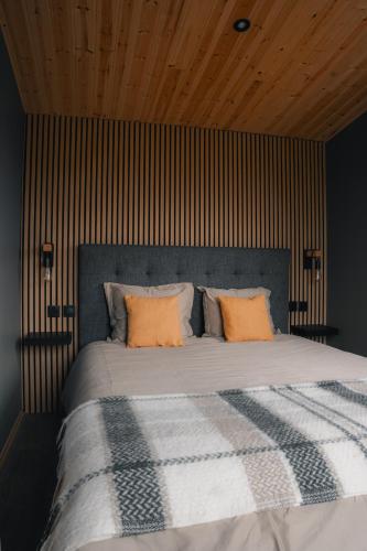 a bedroom with a large bed with orange pillows at Seljalandsfoss cottage in Hvolsvöllur