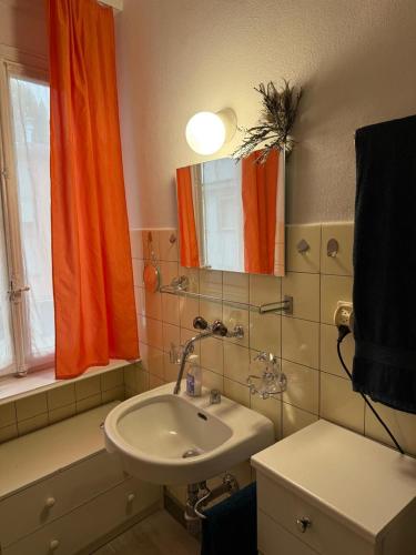 a bathroom with an orange curtain and a sink at CASA-DOYA Appartamento in centro in Muralto