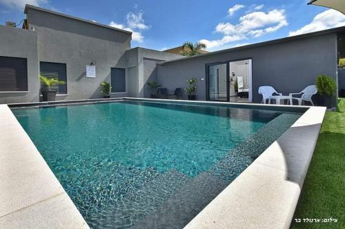 une piscine devant une maison dans l'établissement r בוטיק, à Manot
