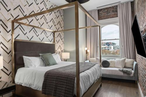 a bedroom with a canopy bed and a window at French's Luxury Condo - Steps from Broadway in Nashville