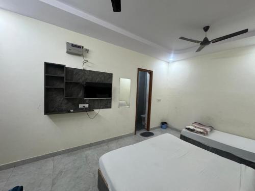 a bedroom with a bed and a tv on the wall at Meera Residency Vrindavan in Vrindāvan