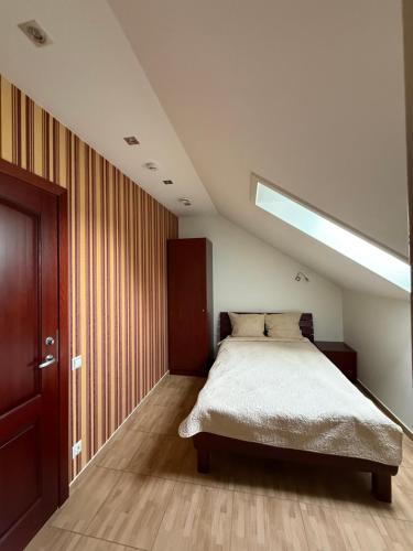 ein Schlafzimmer mit einem Bett und einem Dachfenster in der Unterkunft Gargždų pramogos in Gargždai