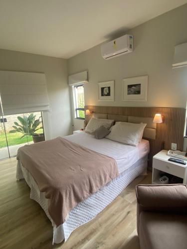 a bedroom with a large bed and a couch at Casa Penedo Vista da Serra in Itatiaia