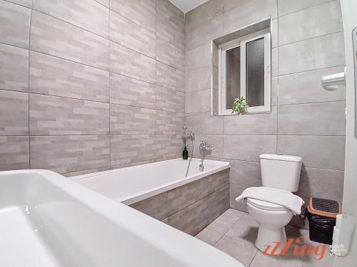 a bathroom with a tub and a toilet and a sink at St Paul's 3BR Apartment - Spectacular Sea Views in St. Paul's Bay
