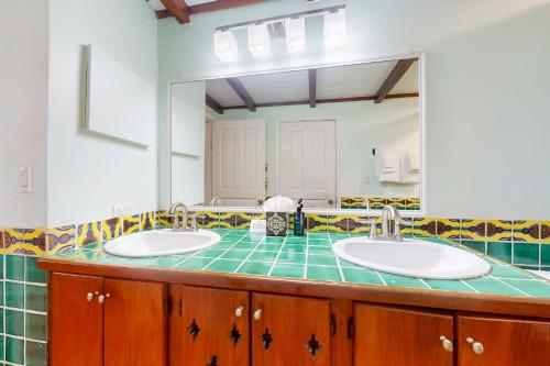 une salle de bain avec deux lavabos et un grand miroir dans l'établissement Condo #24 @ Beachside Villas, à Placencia