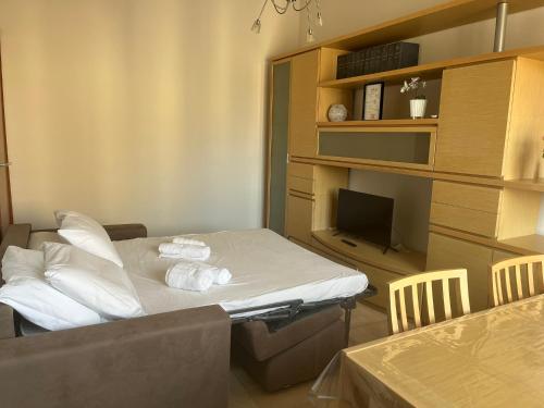 a room with a bed with pillows and a television at sky apartment a due passi dalla stazione in Collegno