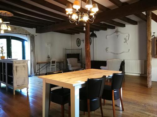 een eetkamer met een houten tafel en stoelen bij Maison 3 in Souvigny