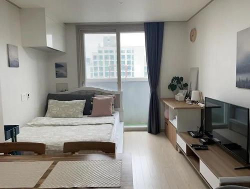 アンサンにあるHigh City view Room with Netflixのベッドと大きな窓のある寝室
