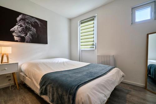 Schlafzimmer mit einem Bett mit Löwenbild an der Wand in der Unterkunft Le Duo - Les Demeures d'Adrien in Carvin