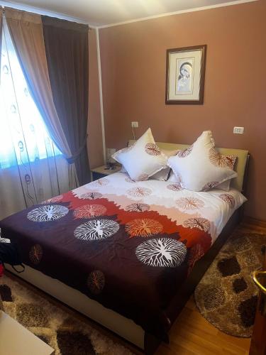 una camera da letto con un letto con un piumone e cuscini di La Mary a Borşa