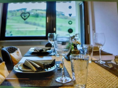 einen Tisch mit Weingläsern und einen Tisch mit Aussicht in der Unterkunft Brandenkopfblick in Oberharmersbach
