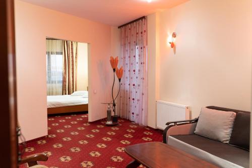 un salon avec un canapé et un lit dans l'établissement Hotel Coral, à Satu Mare