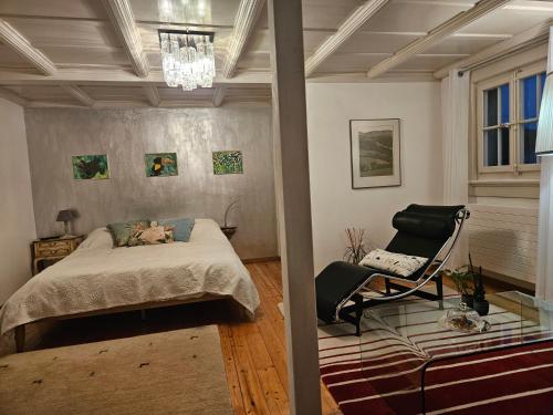 un dormitorio con una cama y una silla en Sunnegg, en Huttwil