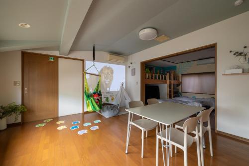 a living room with a table and chairs and a bedroom at 恐竜好きの小さなお子様連れのご家族におすすめ宿 じゅらどんの家 in Katsuyama