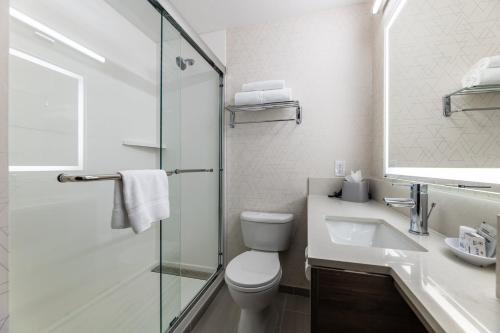 a bathroom with a toilet and a sink and a shower at Holiday Inn Express Van Nuys by IHG in Van Nuys