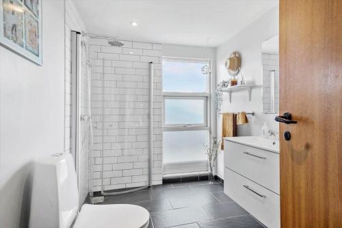 Un baño blanco con inodoro y ventana. en FY403-Asperup-Eskelundsvaenget-1, en Voldby