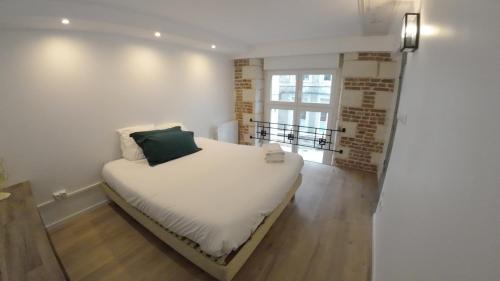 a small bedroom with a white bed and a window at Loft industriel - hyper centre cambrai in Cambrai