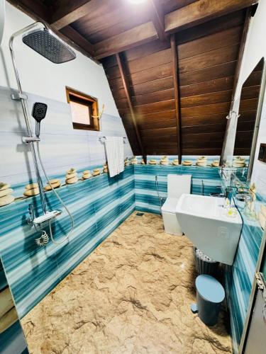 a bathroom with blue tiles and a sink at Soluna Cove luxury Cabanas Hikkaduwa in Hikkaduwa