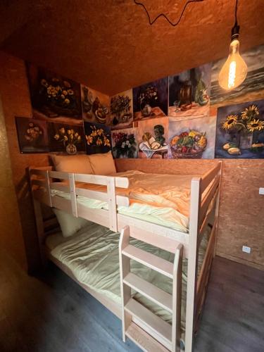 a bedroom with two bunk beds and a wall with pictures at kunstig appartement in Poelkapelle