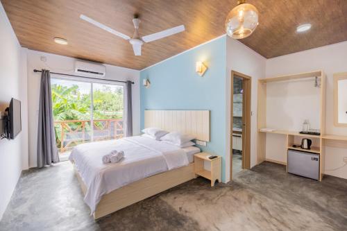 Un dormitorio con una cama grande y una ventana en Bibee Surf, en Thulusdhoo