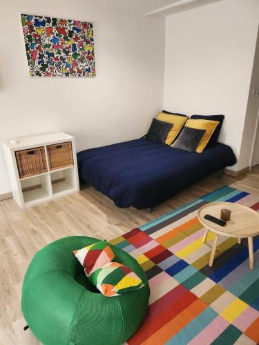 a living room with a bed and a table at Spacieux Studio Sushi - 1 lit double - Rue calme- Centre ville in Charleville-Mézières