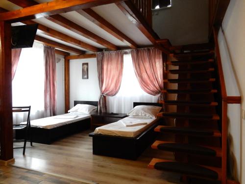 Zimmer mit 2 Betten und einer Treppe mit Fenstern in der Unterkunft Aparthotel Metropol in Iaşi