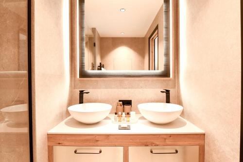 a bathroom with two sinks and a mirror at Chalet Mademoiselle in Les Allues