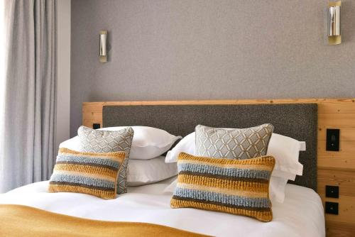 a bedroom with a bed with two pillows at Chalet Mademoiselle in Les Allues
