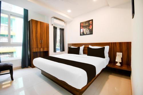 a bedroom with a large bed and a window at Super Townhouse Sayhallo Narcos in Bhubaneshwar