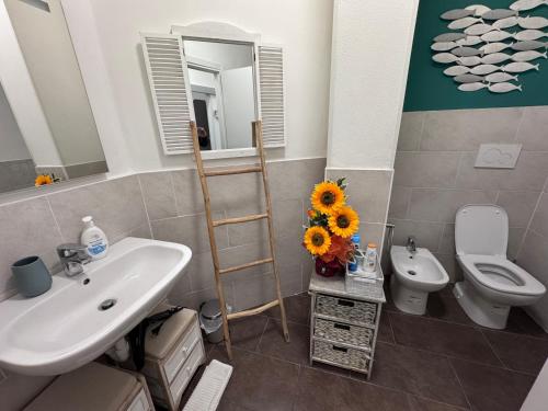 a bathroom with a sink and a toilet and a mirror at Casa SERGE vista mare con ampio terrazzo privato in Bergeggi