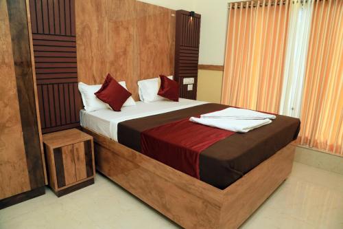 Bekal Eden Resort في Kotikulam: غرفة نوم بسرير كبير مع وسائد حمراء