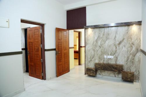 Bekal Eden Resort في Kotikulam: ممر بأبواب خشبية وجدار حجري