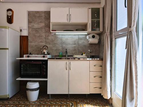 a kitchen with white cabinets and a black oven at Depto 1615 in Villa Mercedes