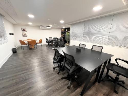 ein Büro mit einem Schreibtisch, Stühlen und einem Tisch in der Unterkunft Apto moderno c/ Vista Incrível para o Mar in Insel Itaparica