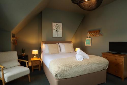 a bedroom with a bed and a chair and a television at The Albany Rooms Bexhill in Bexhill