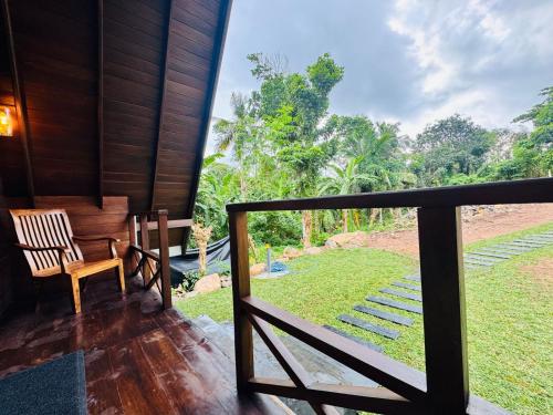 Un porche con una silla y vista a un patio. en Soluna Cove Cabanas Hikkaduwa, en Hikkaduwa