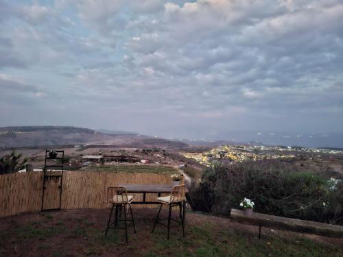 a table and two chairs sitting on top of a hill at צימר תומר דבורה-קצה ההר in Kerem Ben Zimra