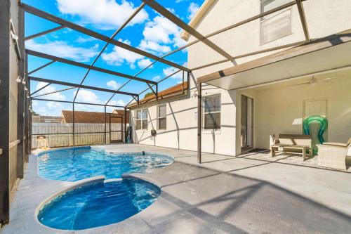 an indoor swimming pool in a house with a glass ceiling at Beautiful 5BR 4 baths Themed home near Disney and Universal, Private Pool, Gameroom, baby Crib and more in Kissimmee