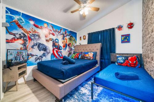 a bedroom with two beds and a superhero mural at Beautiful 5BR 4 baths Themed home near Disney and Universal, Private Pool, Gameroom, baby Crib and more in Kissimmee
