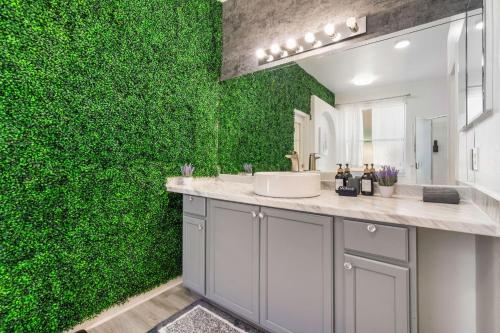 a green wall in a bathroom with a sink at Beautiful 5BR 4 baths Themed home near Disney and Universal, Private Pool, Gameroom, baby Crib and more in Kissimmee
